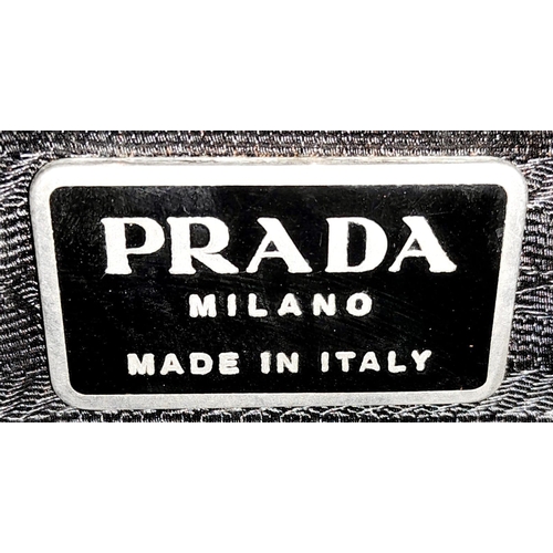 513 - A Prada Green Tessuto Handbag. Textile exterior with plastic handle and velcro top closure. Black te... 