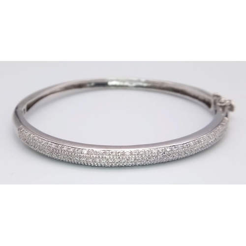 61 - A PRETTY 9K WHITE GOLD DIAMOND SET BANGLE WITH APPROX 0.60CT DIAMONDS IN TOTAL, WITH SAFETY CATCH AT... 