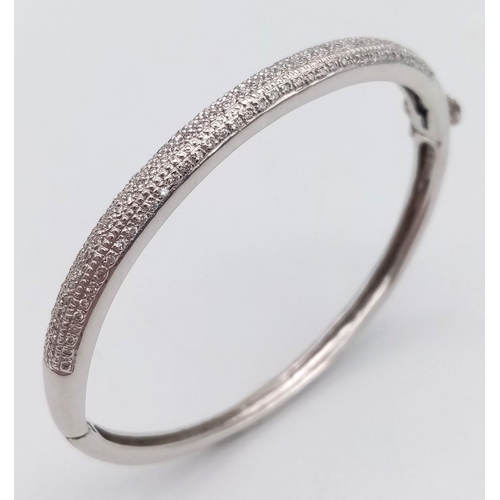 61 - A PRETTY 9K WHITE GOLD DIAMOND SET BANGLE WITH APPROX 0.60CT DIAMONDS IN TOTAL, WITH SAFETY CATCH AT... 