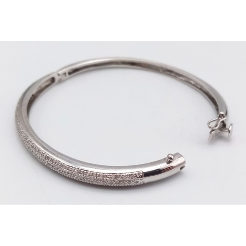 61 - A PRETTY 9K WHITE GOLD DIAMOND SET BANGLE WITH APPROX 0.60CT DIAMONDS IN TOTAL, WITH SAFETY CATCH AT... 