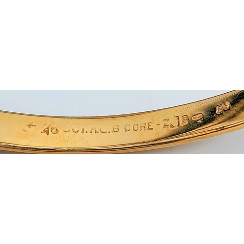 71 - A 9 K yellow gold bangle with a decorative engraving on top half, weight: 12.4g