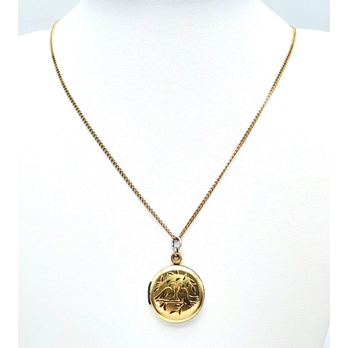 92 - A 9 K yellow gold locket with two loving birds sitting on a branch engraved on the front. With a cha... 