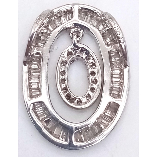 334 - An 18K White Gold Diamond Pendant. Hanging round cut diamond oval within a baguette diamond oval. 0.... 