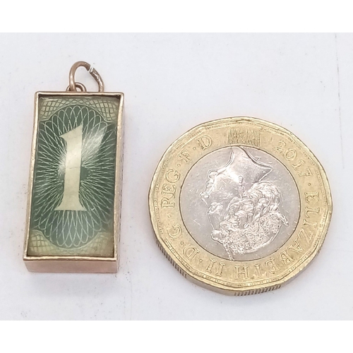 345 - A 9 K yellow gold charm/pendant with an old £1 note inside and the inscription: 