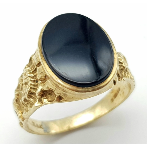 A 9 k yellow gold fancy cygnet ring with an oval cut black onyx, size ...