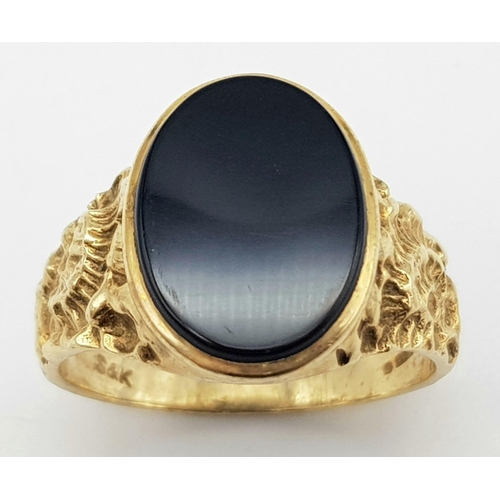 502 - A 9 k yellow gold fancy cygnet ring with an oval cut black onyx, size: W, weight: 5.4 g.