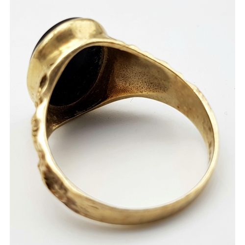 502 - A 9 k yellow gold fancy cygnet ring with an oval cut black onyx, size: W, weight: 5.4 g.