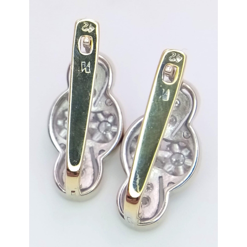 9 - An 18 K white and yellow gold pair of earrings with a nice, diamond set design, length: 21 mm, weigh... 