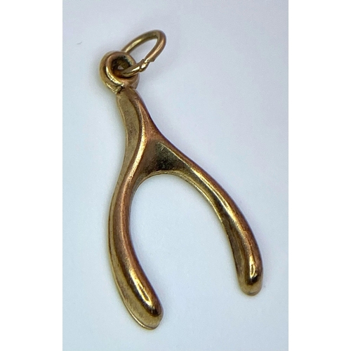 822 - A 9K YELLOW GOLD WISHBONE CHARM. TOTAL WEIGHT 0.4G