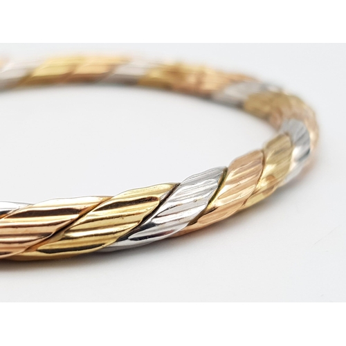 103 - A 9K Tri-Coloured Bangle. 6cm inner diameter. Yellow, white and rose gold. 18.3g weight.