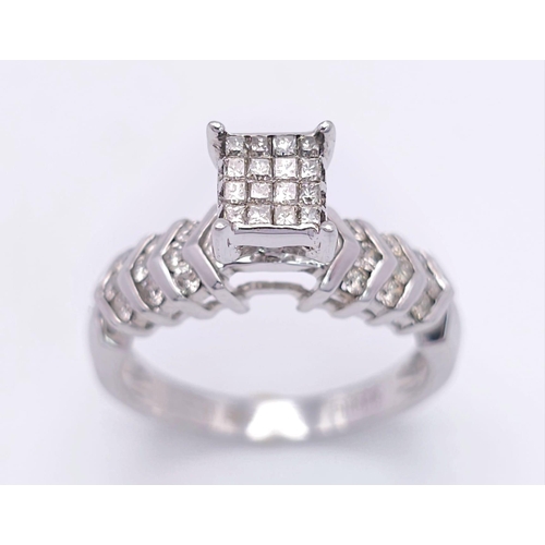 327 - A 14K White Gold Diamond Ring. Miniature square cut diamonds in a raised setting with round cut diam... 