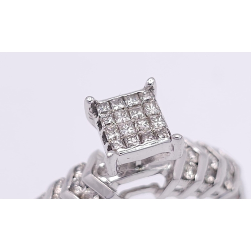 327 - A 14K White Gold Diamond Ring. Miniature square cut diamonds in a raised setting with round cut diam... 