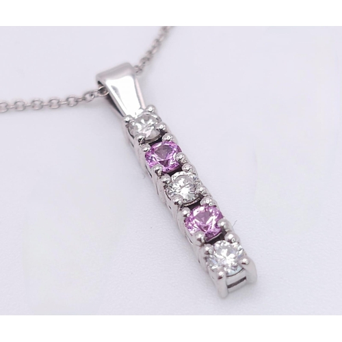 90 - An 18 K white gold drop pendant with diamonds and pink sapphires (rubies) on an 18 K white gold chai... 