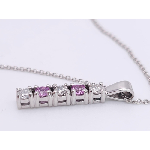 90 - An 18 K white gold drop pendant with diamonds and pink sapphires (rubies) on an 18 K white gold chai... 