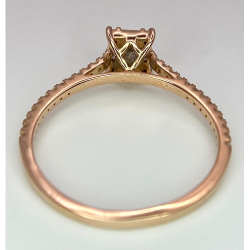 178 - An 18 K rose gold ring with a square emerald cut diamond and more round cut diamonds on the shoulder... 