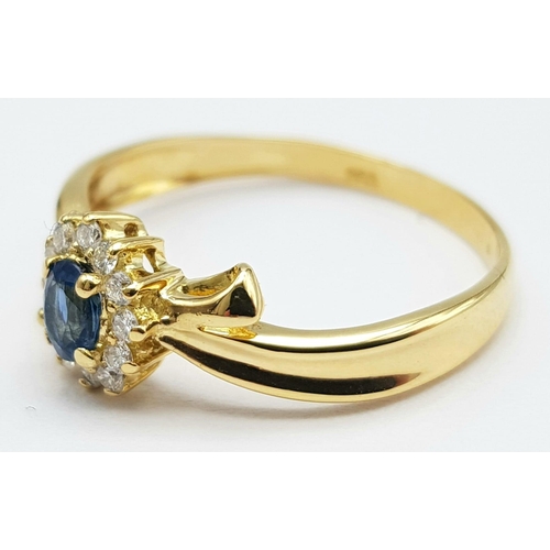 463 - An 18 K yellow gold ring with an oval cut  blue sapphire surrounded by a halo of diamonds. Size: L, ... 