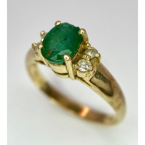 207 - A 14K Yellow Gold Emerald and Diamond Ring. Central oval cut emerald with two round cut diamonds eit... 