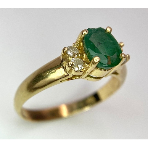 207 - A 14K Yellow Gold Emerald and Diamond Ring. Central oval cut emerald with two round cut diamonds eit... 