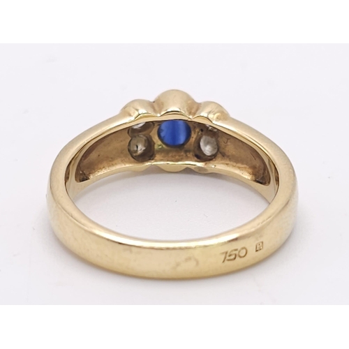 242 - An 18K Yellow Gold (tested) Sapphire and Diamond Ring. Central oval sapphire with two bright diamond... 