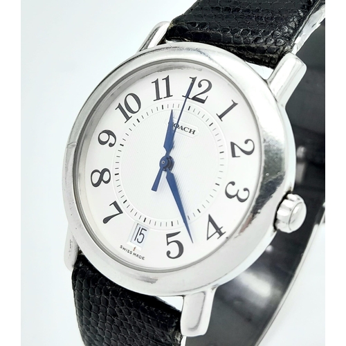 529 - A Coach Quartz Gents Watch. Black leather strap. Stainless steel case. White dial. In working order.