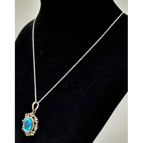 1795 - A Blue Topaz Pendant with Diamond Surround on 925 Silver and Silver Chain. 7.45ct topaz, 1.25ctw dia... 