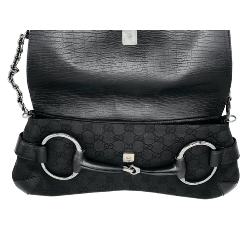 95 - A Gucci GG black canvas bag featuring the black and gunmetal grey horsebit and metal shoulder strap.... 