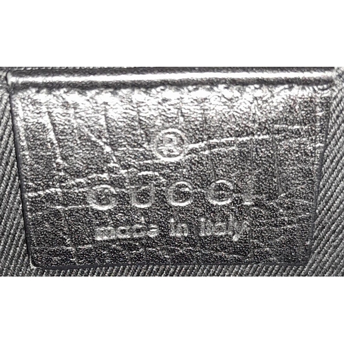 95 - A Gucci GG black canvas bag featuring the black and gunmetal grey horsebit and metal shoulder strap.... 