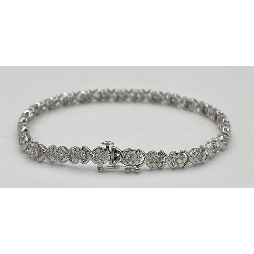 151 - A 9K White Gold Diamond Tennis Bracelet in a Criss-Cross Link Formation. 17cm length. 5.5g total wei... 