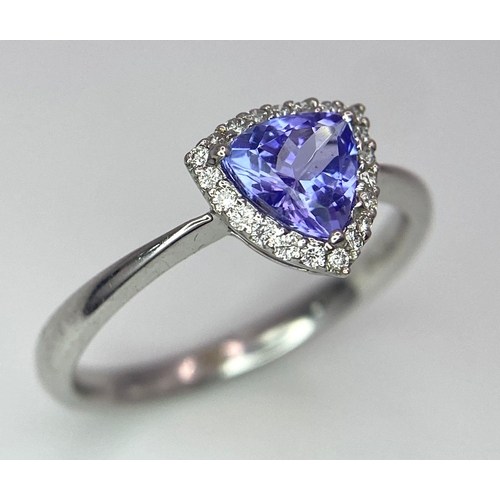 232 - A 9K White Gold Tanzanite and Diamond Ring. Trillion cut tanzanite with a diamond surround. Size N. ... 