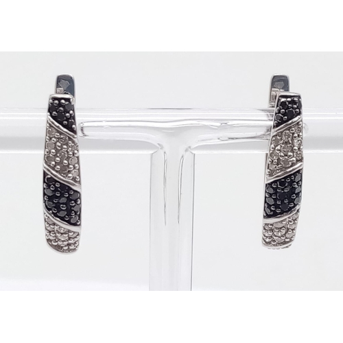 477 - An interesting , 9 K white gold pair of earrings with black and white diamonds, length: 20 mm, weigh... 