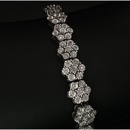 74 - A 9K White Gold Graduated Link Diamond Tennis Bracelet. 29 links of seven small diamonds - 203 total... 