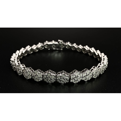 74 - A 9K White Gold Graduated Link Diamond Tennis Bracelet. 29 links of seven small diamonds - 203 total... 