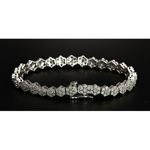 74 - A 9K White Gold Graduated Link Diamond Tennis Bracelet. 29 links of seven small diamonds - 203 total... 