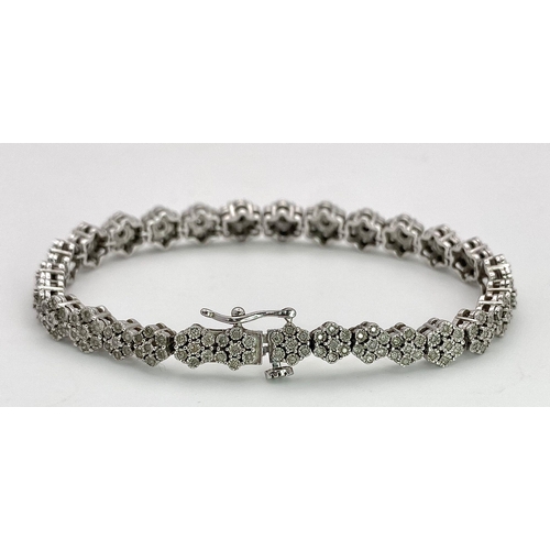 74 - A 9K White Gold Graduated Link Diamond Tennis Bracelet. 29 links of seven small diamonds - 203 total... 