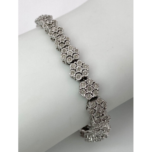 74 - A 9K White Gold Graduated Link Diamond Tennis Bracelet. 29 links of seven small diamonds - 203 total... 