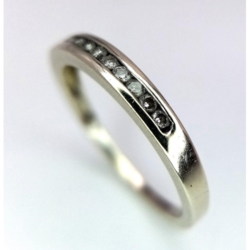 498 - A 9 K white gold ring with a diamond band, size: J, weight: 1.3 g.