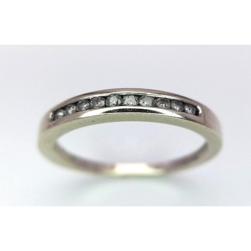 498 - A 9 K white gold ring with a diamond band, size: J, weight: 1.3 g.