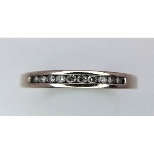 498 - A 9 K white gold ring with a diamond band, size: J, weight: 1.3 g.