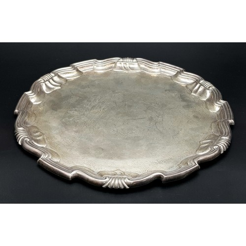 79 - An Antique Sterling Silver Salver with a Decorative scrolled edge. 31cm diameter. 606g weight. Londo... 