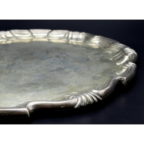 79 - An Antique Sterling Silver Salver with a Decorative scrolled edge. 31cm diameter. 606g weight. Londo... 