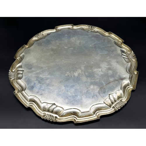 79 - An Antique Sterling Silver Salver with a Decorative scrolled edge. 31cm diameter. 606g weight. Londo... 