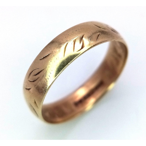 551 - A 9 K yellow gold wedding band ring with engraved surface. size: n, weight; 2.1 g.