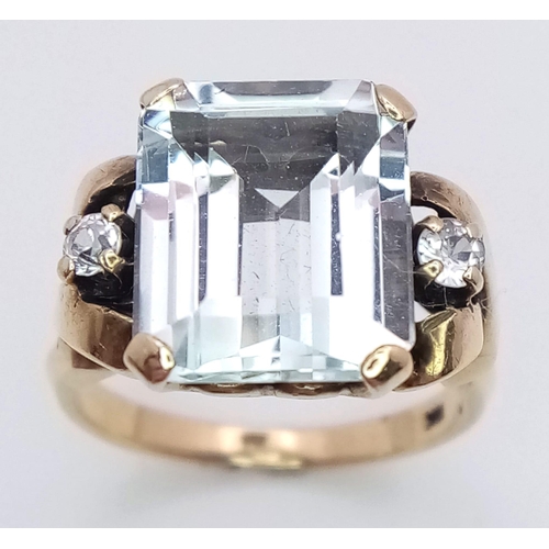 564 - A 10K Yellow Gold Aquamarine and Diamond Ring. 8ct rectangular cut central aquamarine with two brill... 