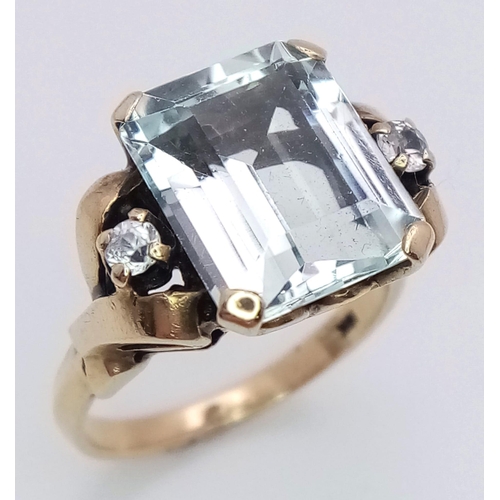 564 - A 10K Yellow Gold Aquamarine and Diamond Ring. 8ct rectangular cut central aquamarine with two brill... 