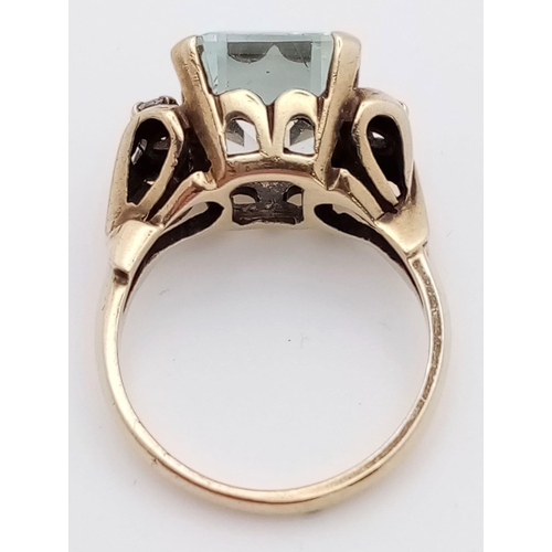 564 - A 10K Yellow Gold Aquamarine and Diamond Ring. 8ct rectangular cut central aquamarine with two brill... 