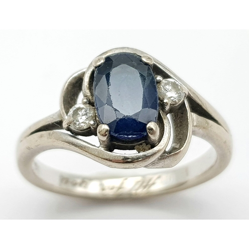 598 - an 18k white gold ring with central sapphire and flanked by 2 small diamonds  . 4.4GMS   size K