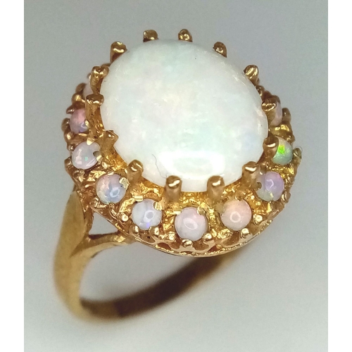 751 - A VERY ATTRACTIVE 9K GOLD AUSRALIAN OPAL RING SURROUNDED BY COLORE PLAY OPALS .    4.8gms    size P