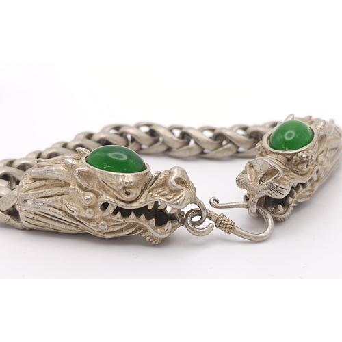 790 - A Tibetan Silver Double Headed Dragon Bracelet. Decorative jade cabochon heads. 24cm