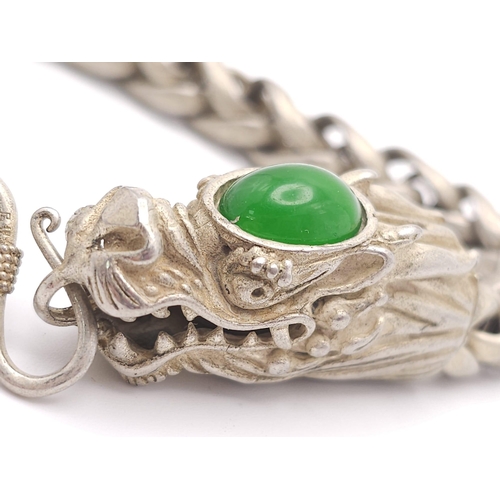 790 - A Tibetan Silver Double Headed Dragon Bracelet. Decorative jade cabochon heads. 24cm