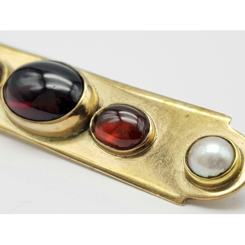 813 - AN EDWARDIAN 15K GOLD BAR BROOCH WITH SEED PEARLS , CARNELIAN AND CENTRAL GARNET  .  9.4gms   6cms w... 